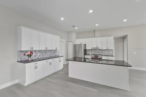 a view of a kitchen and a refrigerator