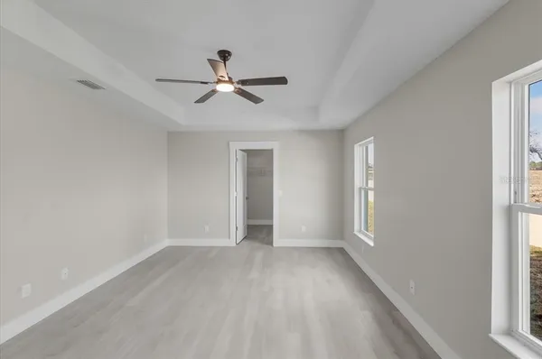 a view of a livingroom with a ceiling fan & hardwood floor