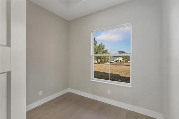 an empty room with a window and a ceiling fan