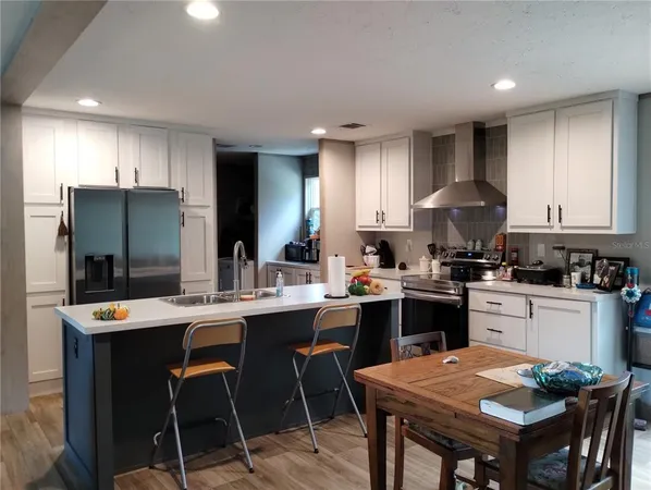 a kitchen with a table chairs refrigerator and cabinets