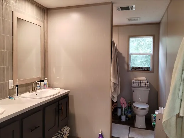 a bathroom with a toilet sink and mirror