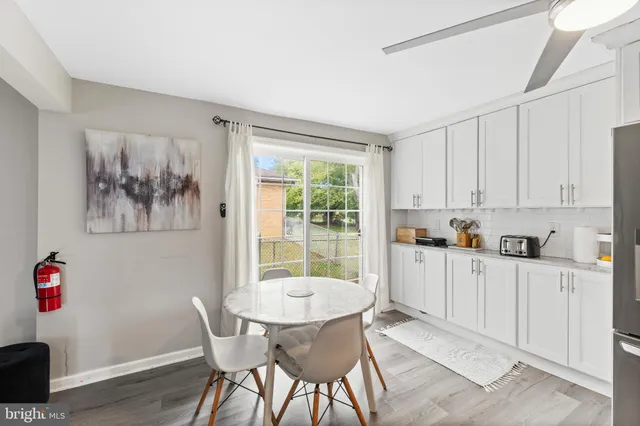 a kitchen with granite countertop a dining table chairs and white cabinets