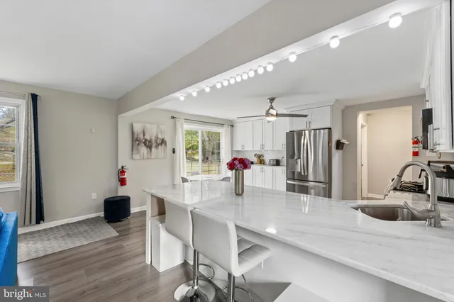 a kitchen and a dining table with wooden floor