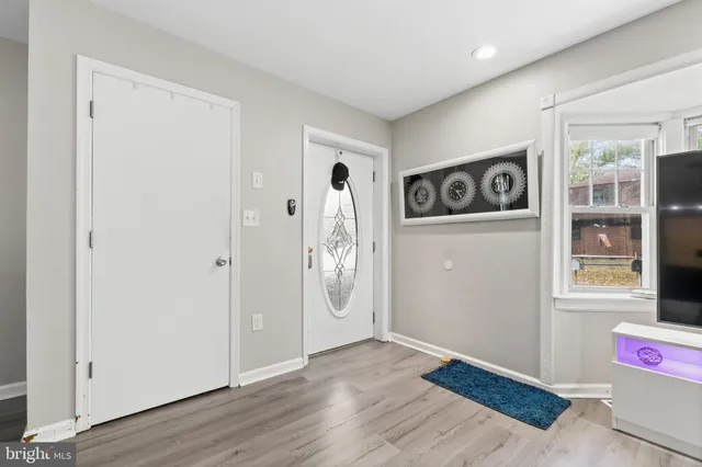 a view of an empty room with wooden floor and window