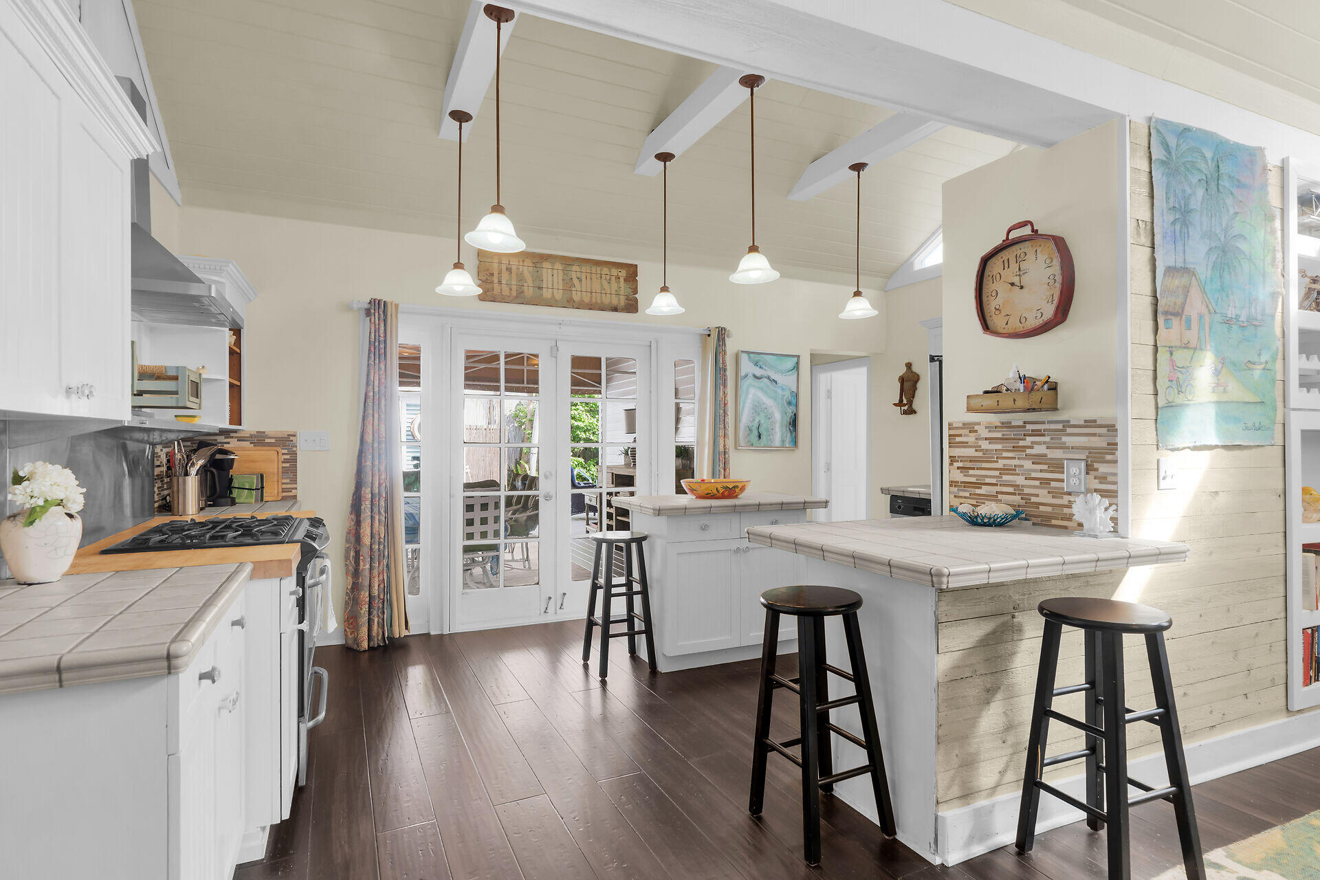 1109 Stump Lane Key West, FL 33040 - Photo 12 of 46 a kitchen with stainless steel appliances granite countertop a stove a refrigerator a oven a dining table and chairs with wooden floor