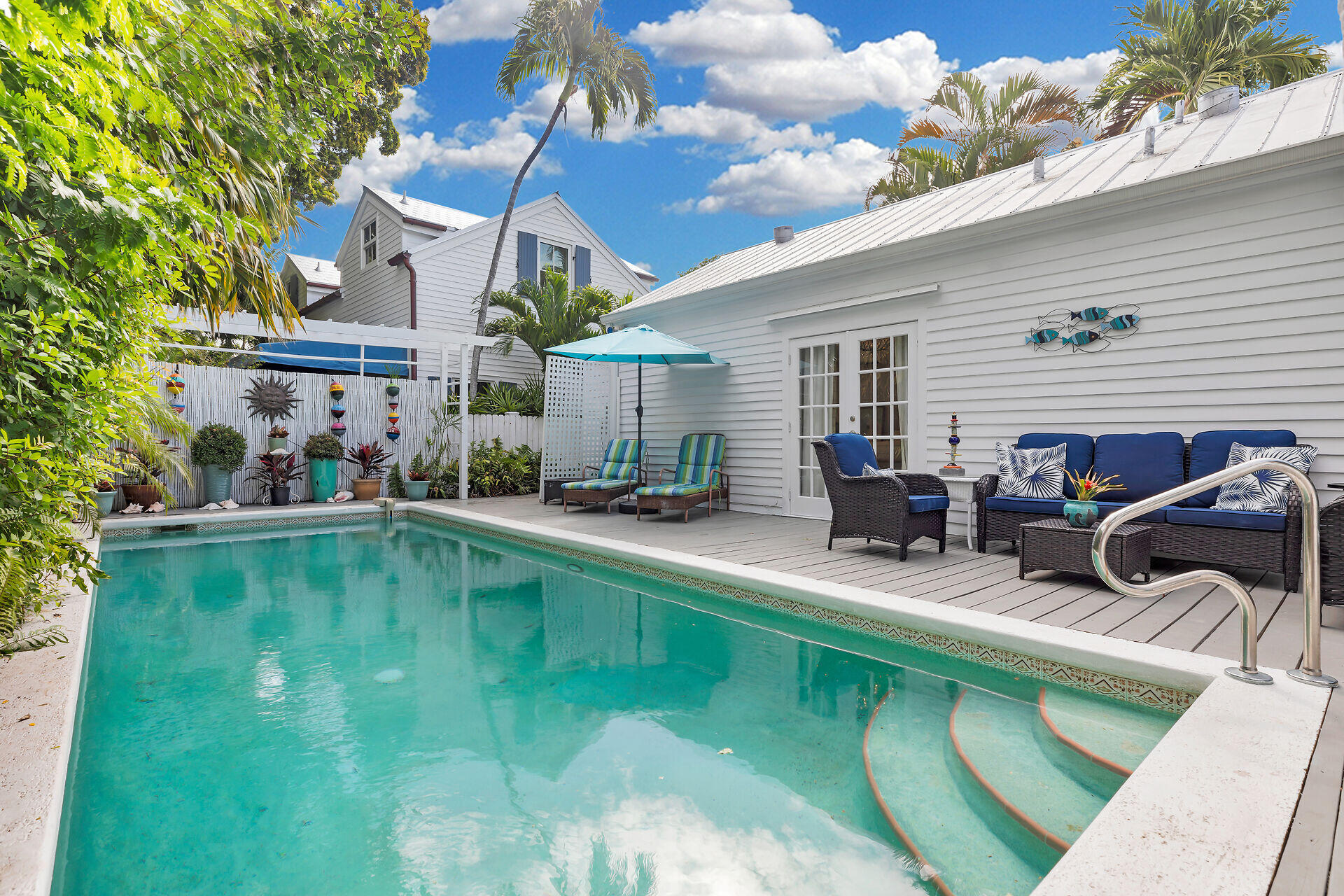 1109 Stump Lane Key West, FL 33040 - Photo 26 of 46 a view of a house with swimming pool lawn chairs and a barbeque