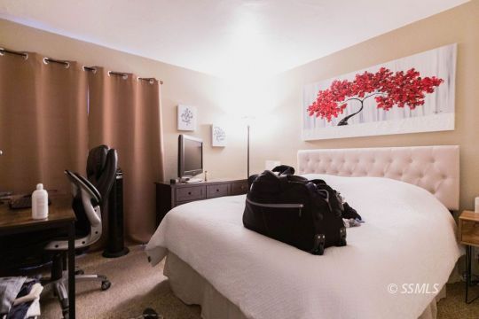 925 West St George Avenue Ridgecrest, CA 93555 - Photo 18 of 24 a bedroom with a bed and a chandelier