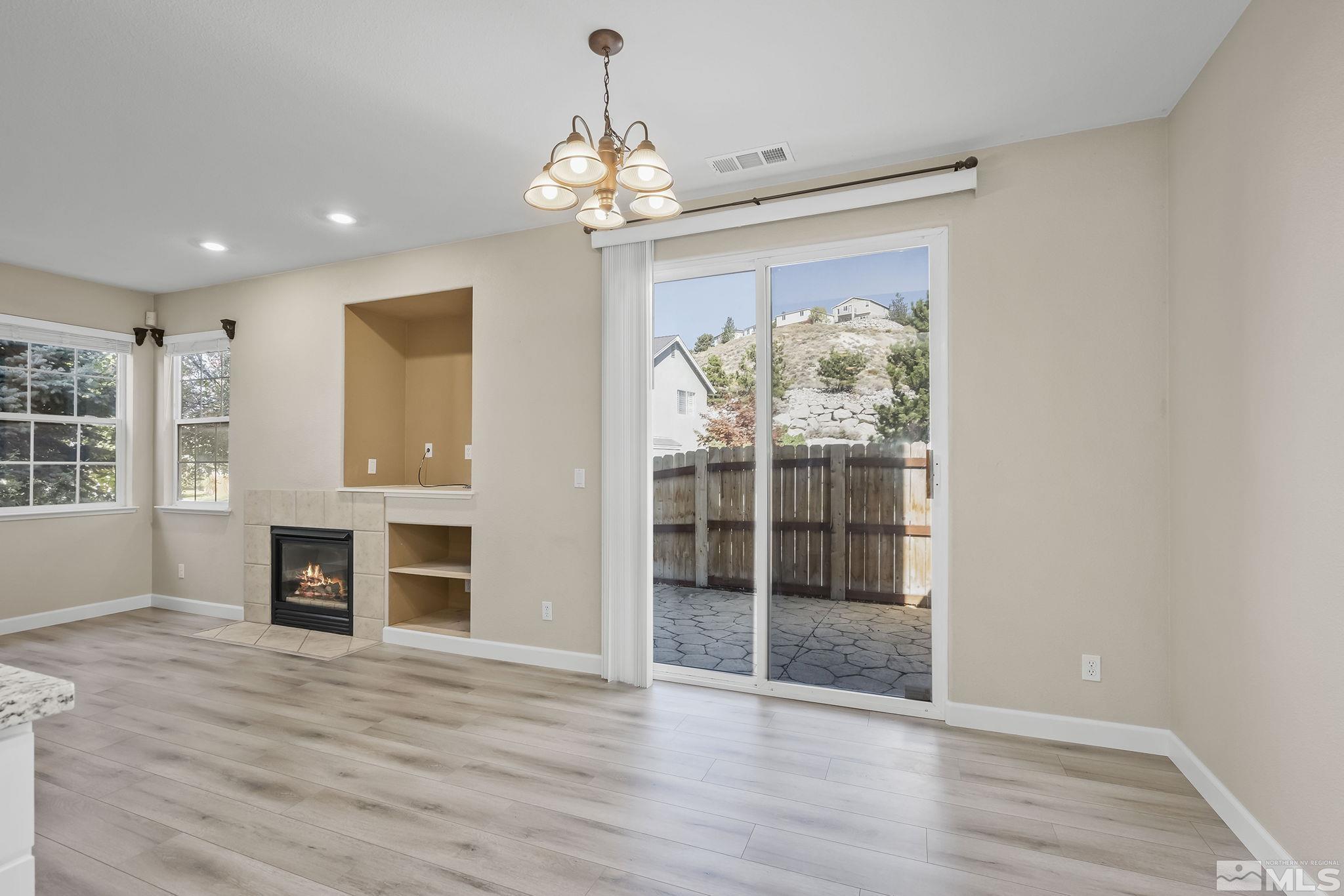 2150 Soldier Pass Court Reno, NV 89523 - Photo 14 of 38 an empty room with wooden floor fireplace and windows