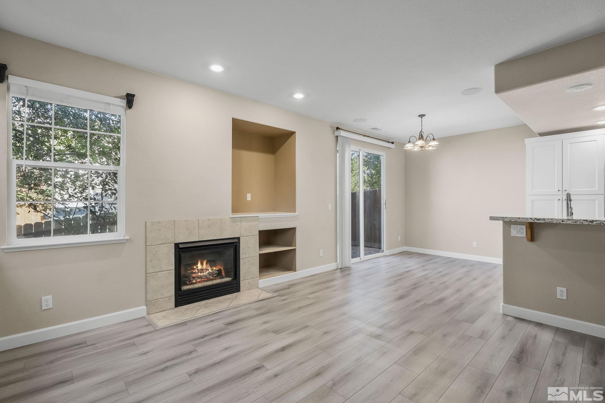 2150 Soldier Pass Court Reno, NV 89523 - Photo 7 of 38 an empty room with wooden floor a fireplace and windows