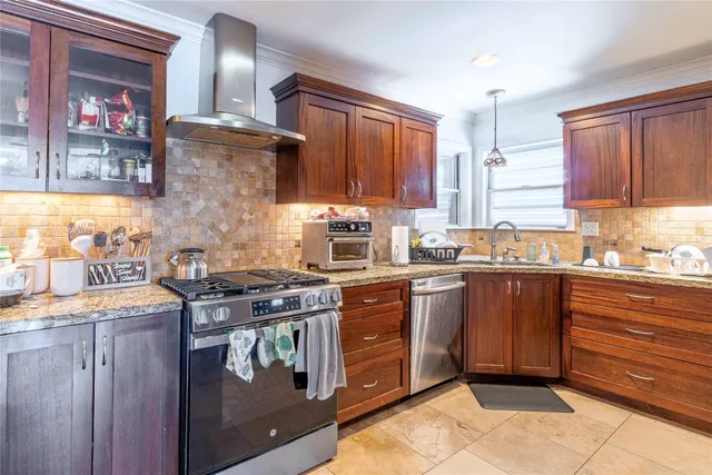 a kitchen with stainless steel appliances kitchen island granite countertop a refrigerator and a sink