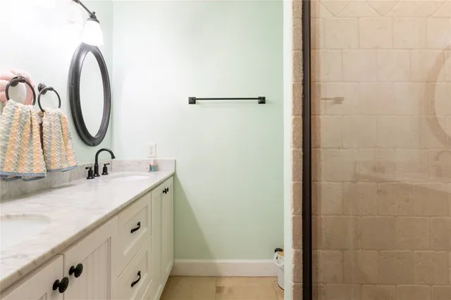 a en suite bathroom with a granite countertop sink and a mirror