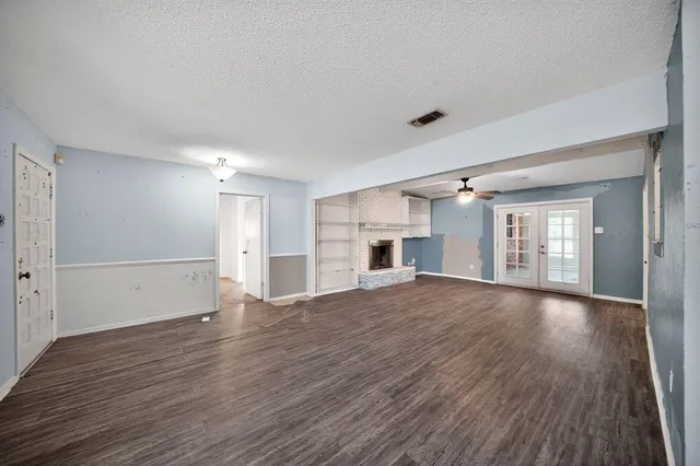 a view of empty room with wooden floor and fireplace