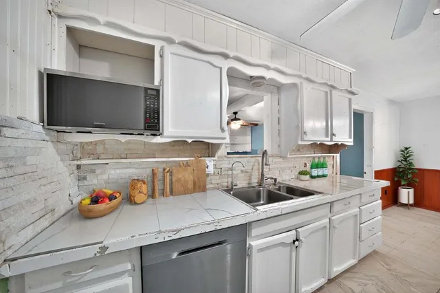a kitchen with a sink a counter space and cabinets