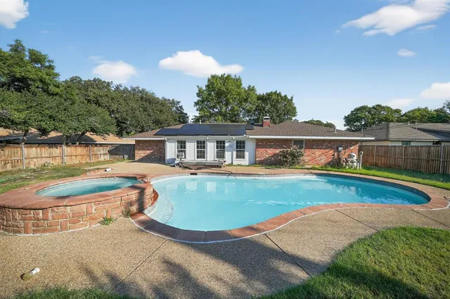 a view of a house with pool and a yard