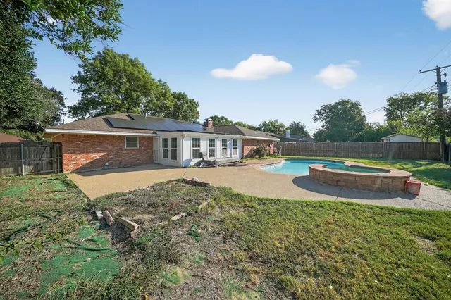 a view of house with backyard and swimming pool