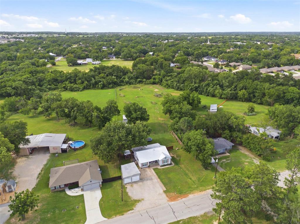 308 West 1st Street Springtown, TX 76082 - Photo 35 of 39 Expansive property featuring a detached garage, a large green space, and mature trees