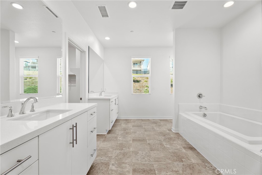 18121 Outlook Way Saugus, CA 91350 - Photo 34 of 59 a spacious bathroom with a bathtub sink double vanity and mirror