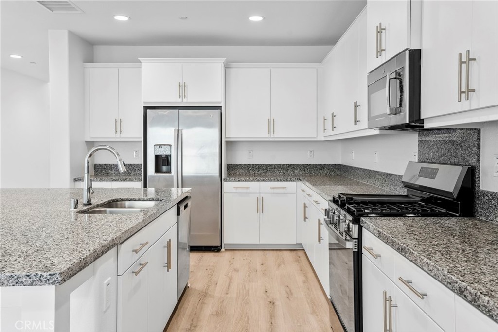 18121 Outlook Way Saugus, CA 91350 - Photo 6 of 59 a kitchen with granite countertop a sink stove and refrigerator