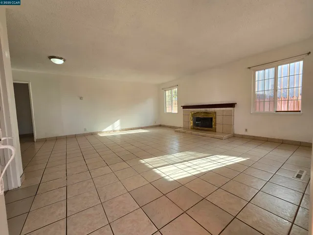 a view of empty room with fireplace and windows