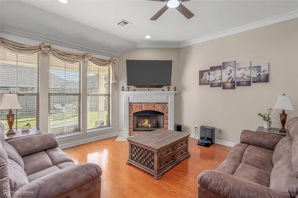 a living room with furniture a flat screen tv and a fireplace