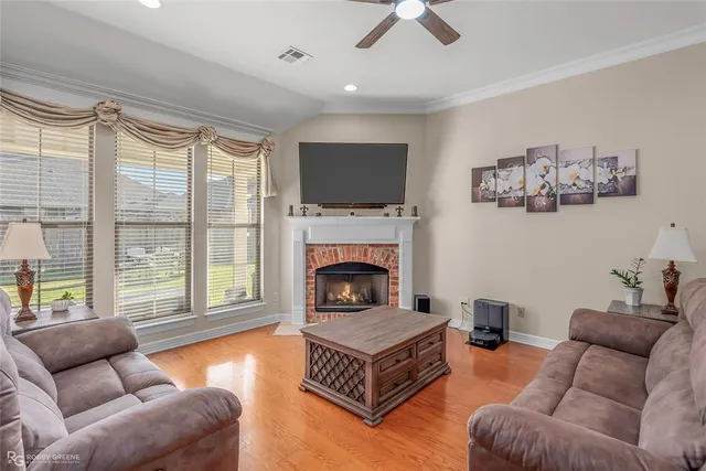 a living room with furniture a flat screen tv and a fireplace
