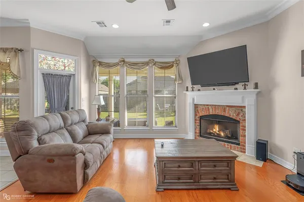 a living room with furniture a flat screen tv and a fireplace