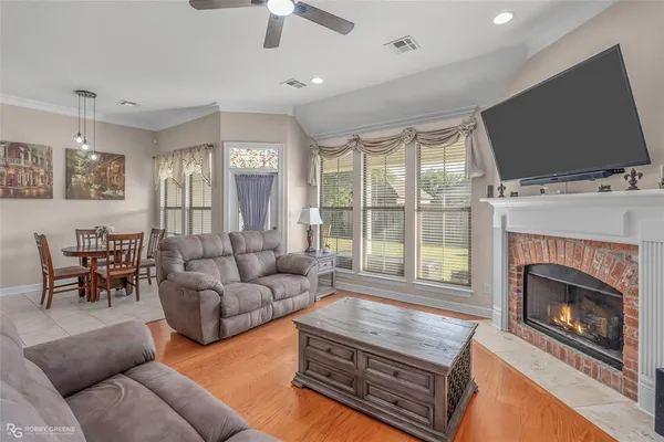 a living room with furniture a flat screen tv and a fireplace