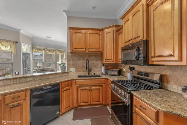 a kitchen with stainless steel appliances granite countertop a stove sink and cabinets