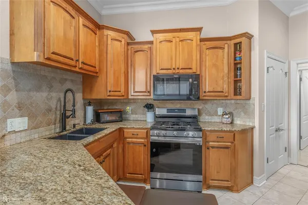 a kitchen with stainless steel appliances granite countertop a stove a sink and a microwave