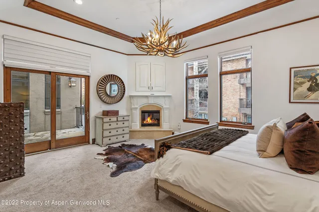 a bedroom with a bed a mirror and a large window