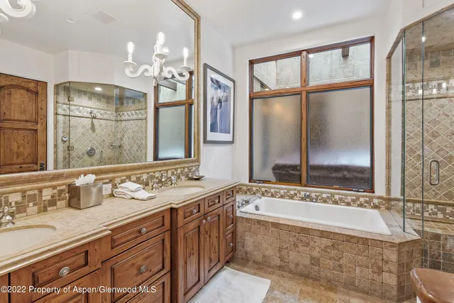 a bathroom with a granite countertop bathtub a double vanity sink and mirror