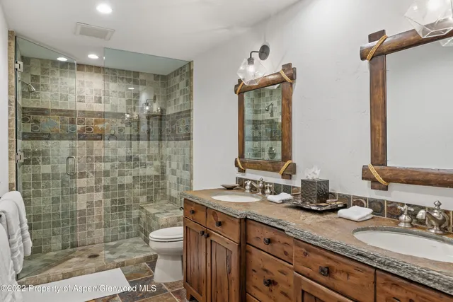 a bathroom with a double vanity sink toilet and shower