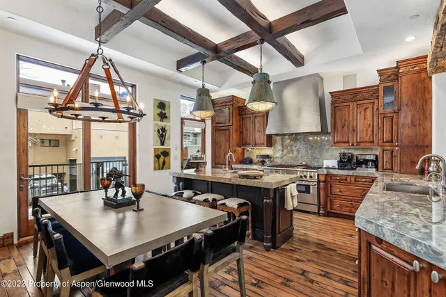 a kitchen with stainless steel appliances granite countertop a stove a sink dishwasher and a refrigerator with wooden floor