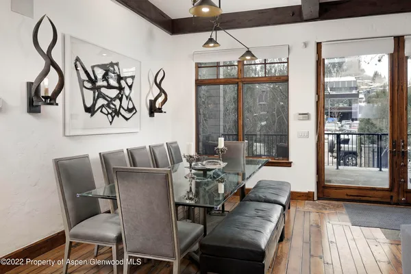 a view of a dining room with furniture wooden floor and a floor to ceiling window