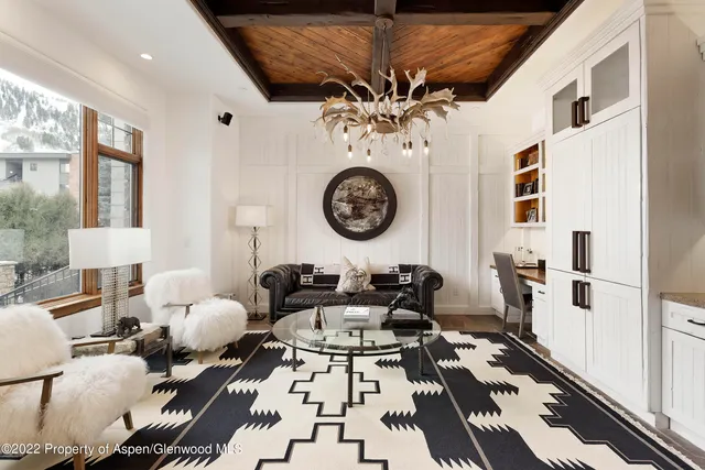 a living room with furniture a clock and a large window