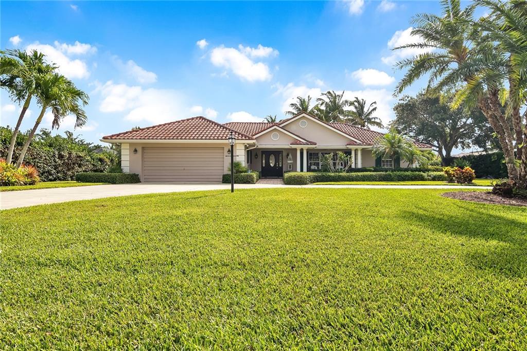 1626 Indian Bay Drive Vero Beach, FL 32963 - Photo 2 of 35 a front view of a house with yard and green space