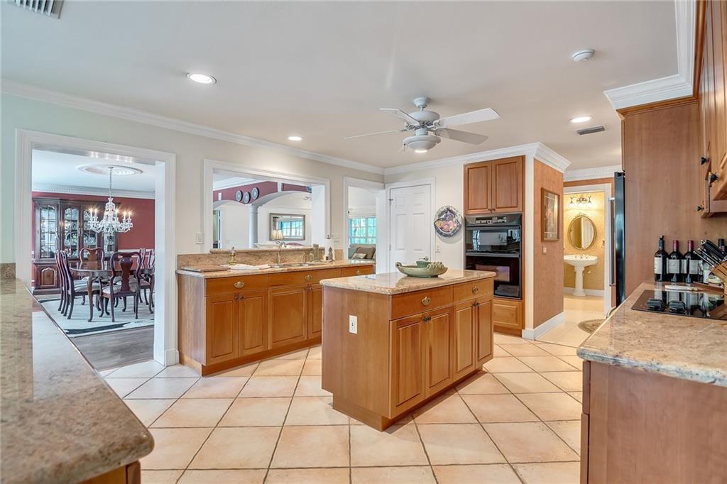 1626 Indian Bay Drive Vero Beach, FL 32963 - Photo 12 of 35 a large kitchen with stainless steel appliances kitchen island granite countertop a refrigerator and a sink