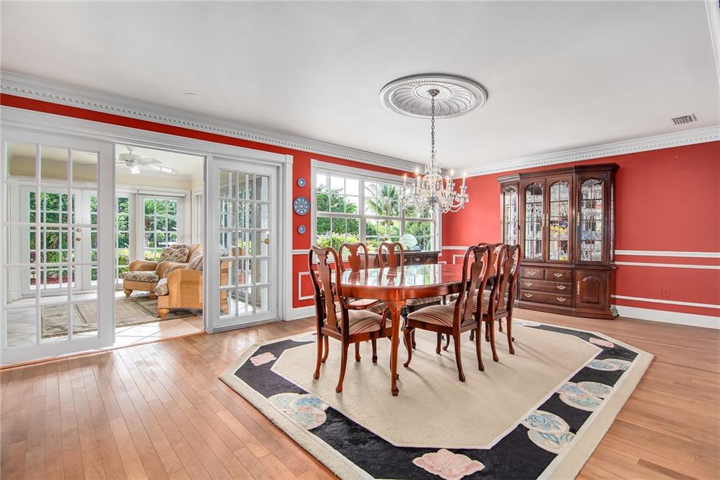 1626 Indian Bay Drive Vero Beach, FL 32963 - Photo 13 of 35 a dining room with furniture a chandelier and wooden floor