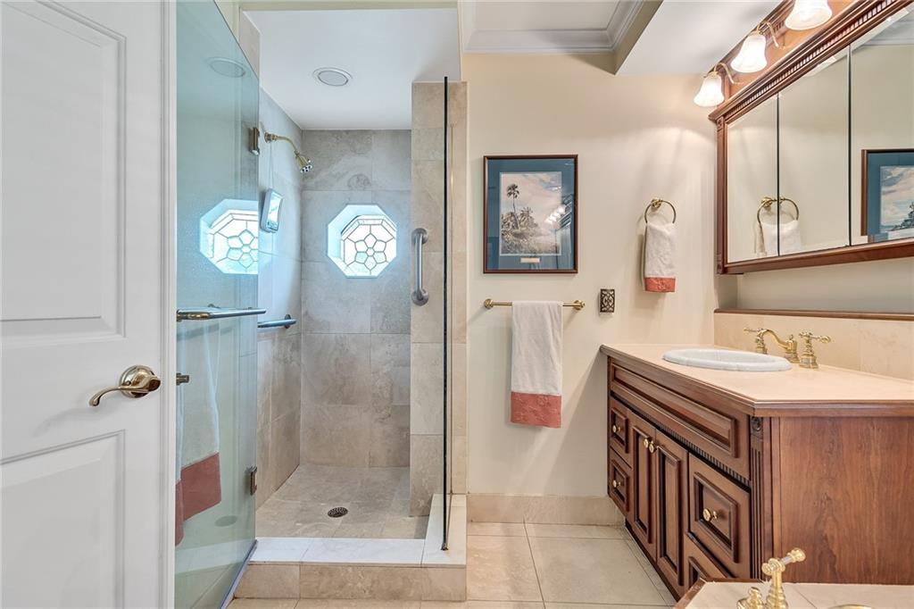 1626 Indian Bay Drive Vero Beach, FL 32963 - Photo 22 of 35 a bathroom with a sink a mirror and a shower