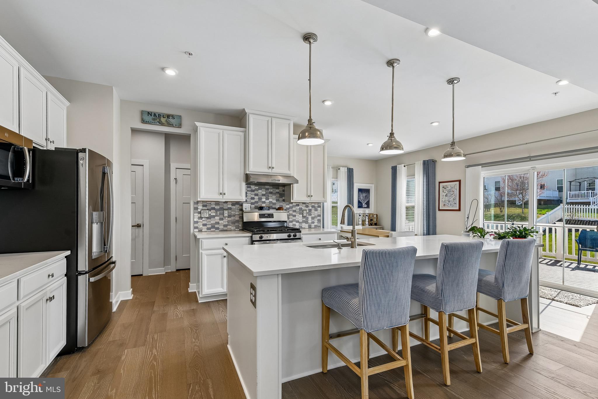 637 Iron Gate Road Bel Air, MD 21014 - Photo 10 of 35 a kitchen with stainless steel appliances kitchen island granite countertop a table chairs and a refrigerator