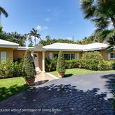 a front view of a house with a yard and fountain in middle