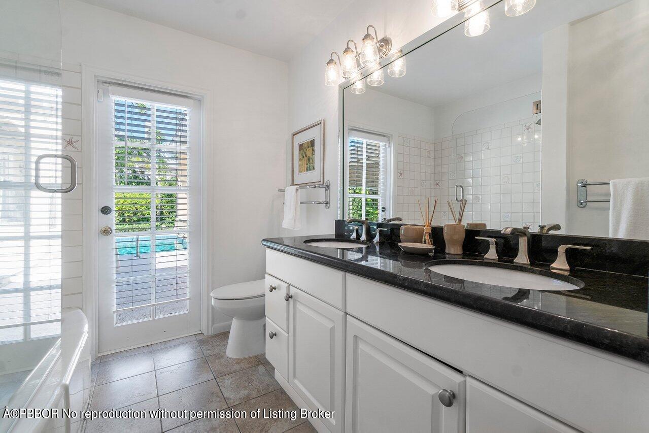 257 Fairview Road Palm Beach, FL 33480 - Photo 14 of 20 a bathroom with a double vanity sink a toilet and a mirror