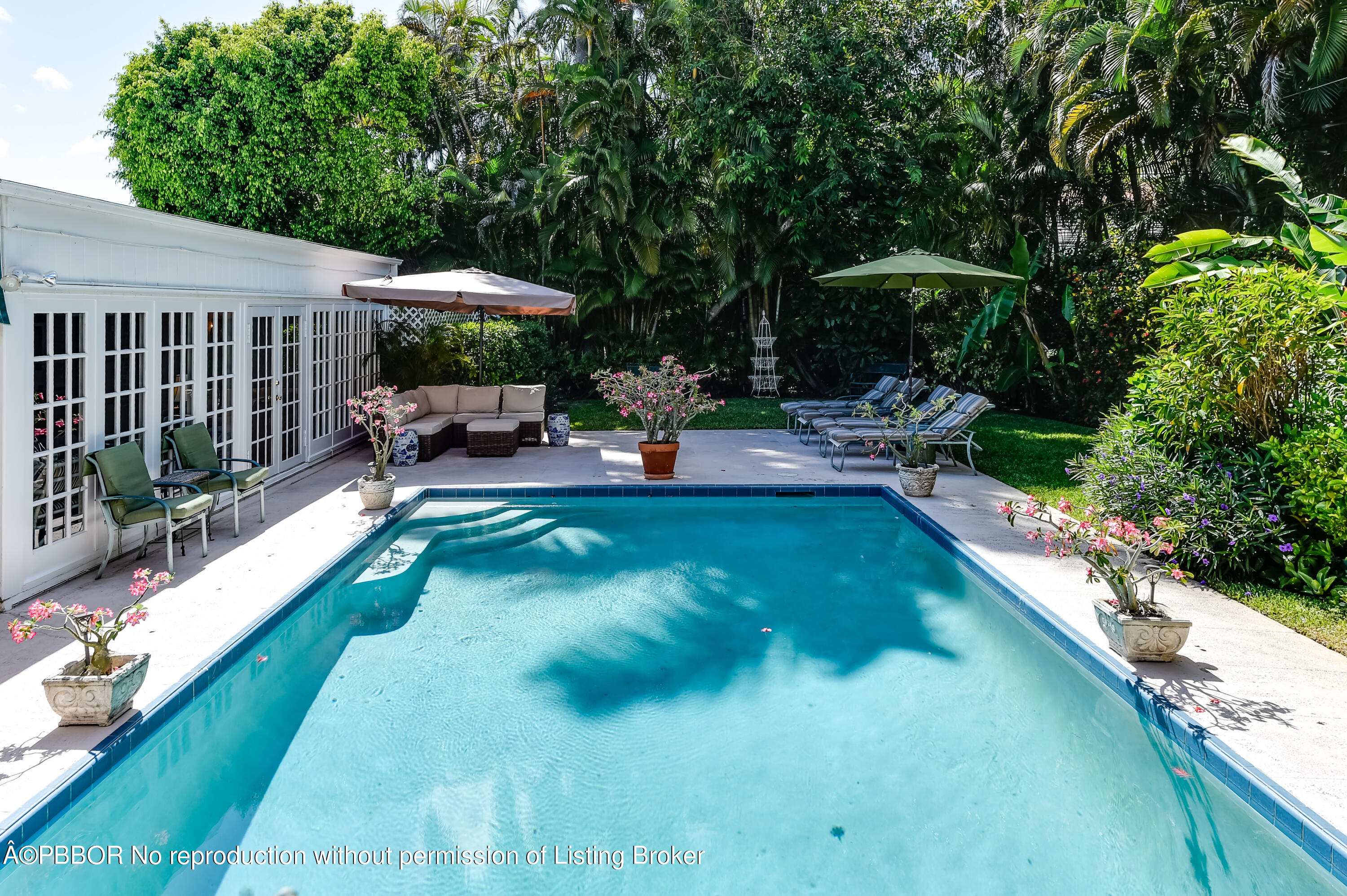 257 Fairview Road Palm Beach, FL 33480 - Photo 15 of 20 a view of a swimming pool with a patio and a garden