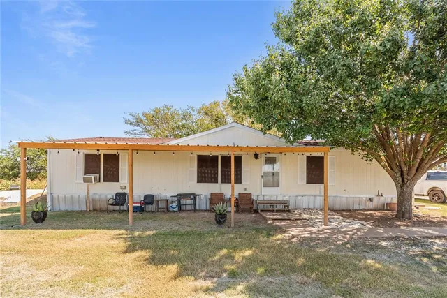 a view of a house with backyard and a tree