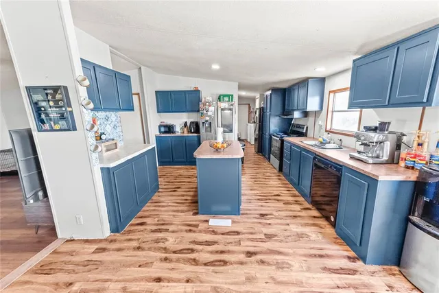a kitchen with stainless steel appliances granite countertop a refrigerator and a stove top oven