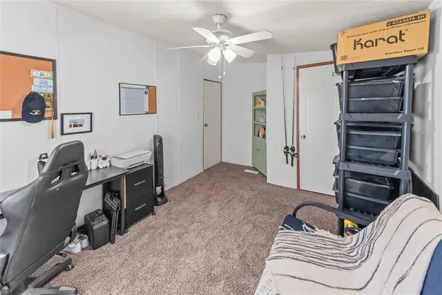 a backyard of a house with table and chairs under an umbrella