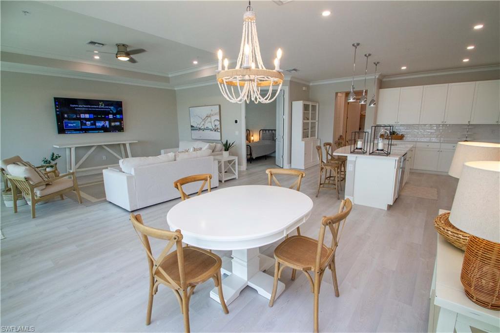 251 Indies Drive East, Unit 202 Naples, FL 34114 - Photo 14 of 48 a view of a dining room with furniture and wooden floor
