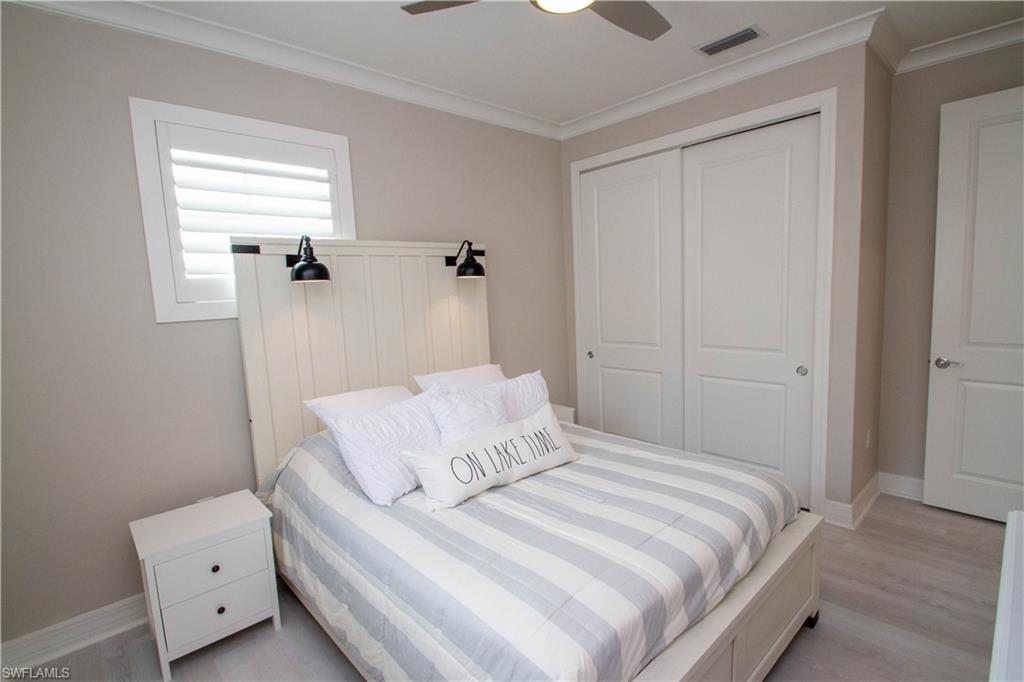 251 Indies Drive East, Unit 202 Naples, FL 34114 - Photo 21 of 48 a bedroom with a bed and a closet