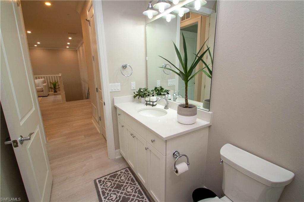 251 Indies Drive East, Unit 202 Naples, FL 34114 - Photo 24 of 48 a spacious bathroom with a double vanity sink toilet and a mirror