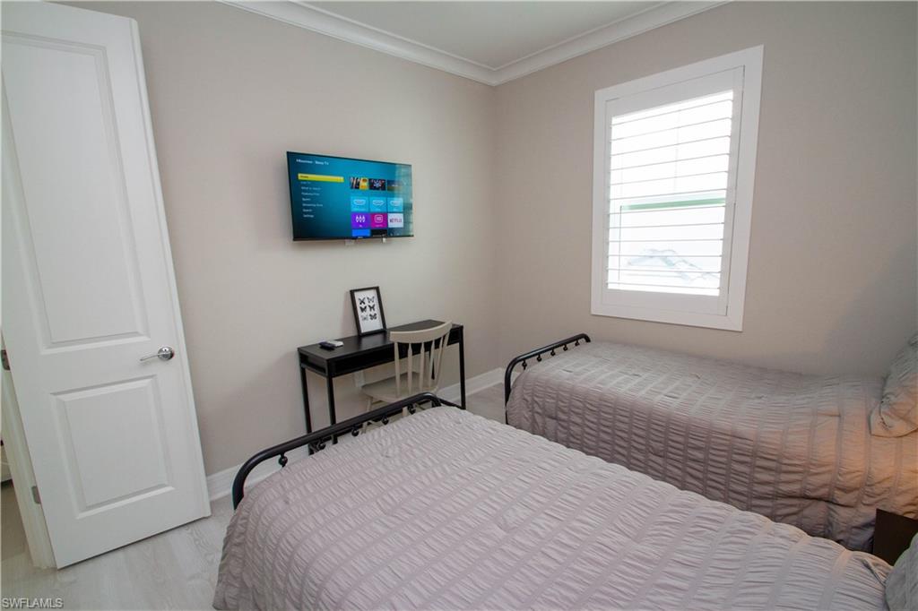 251 Indies Drive East, Unit 202 Naples, FL 34114 - Photo 27 of 48 a bedroom with a bed and a window
